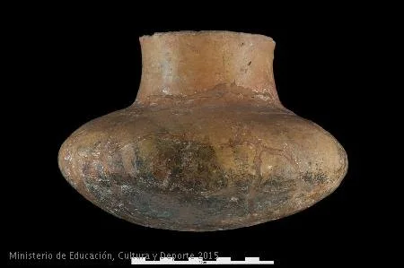 Botella de cuerpo globular, cuello cilíndrico y boca sin borde, con reborde en el interior del cuello. En la zona de la carena se observan posibles restos de decoración a base de triángulos de colores rojizo y negro. La superficie del recipiente está bruñida. Foto: MAN / Blog entrecantaros