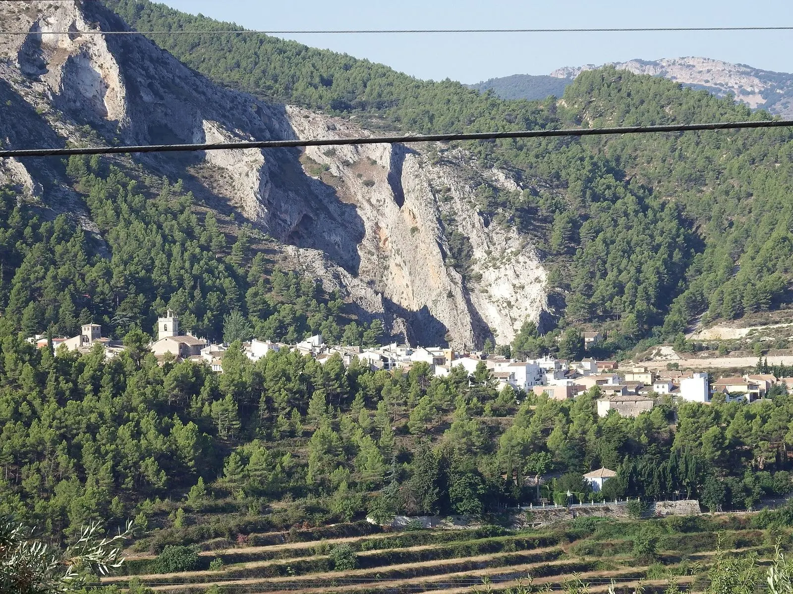 Población de Penàguila entre laderas rocosas y pinares vista desde Benasau