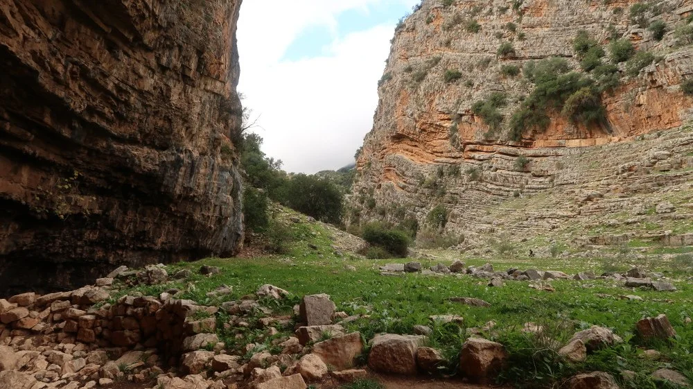 A la izquierda el abrigo de La Tinaja, a la derecha estratos de piedra a modo de gradas. En la parte inferior izquierda podemos distinguir un muro