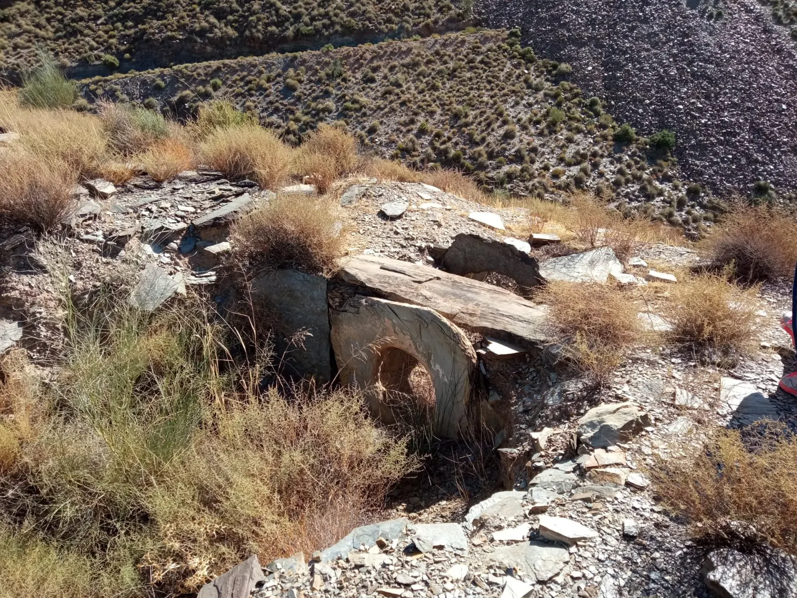 Sepultura tipo tholos con entrada en buen estado de conservación en forma de lajas de pizarra perforadas