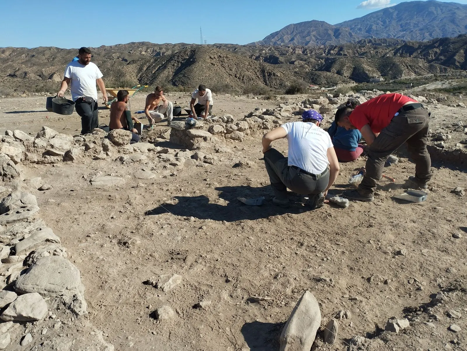 Trabajos de excavación en Los Millares durante una campaña anterior, con varias personas entre estructuras de piedra.