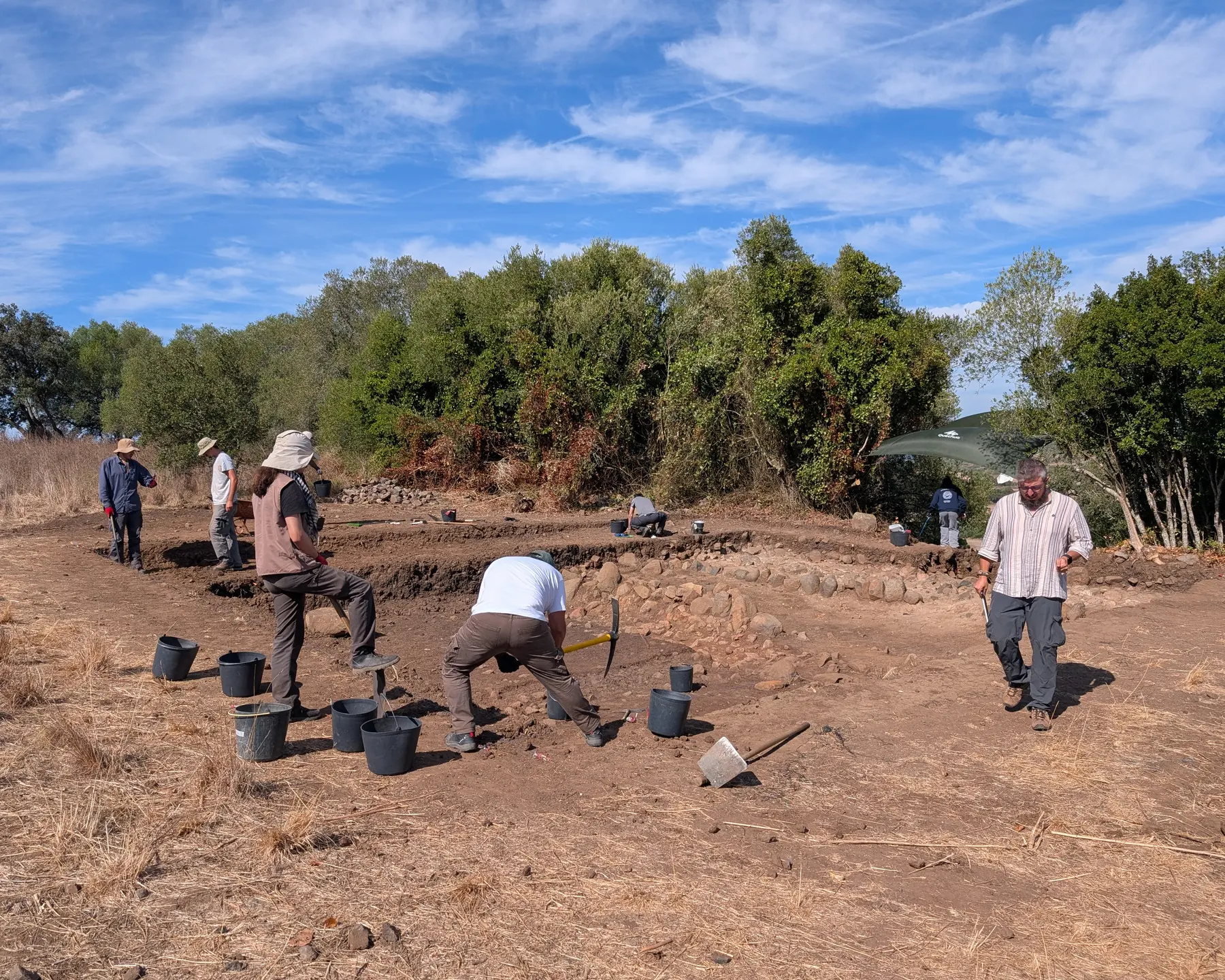 Personas trabajando en la excavación de Outeiro do Circo, con cubos y herramientas sobre el terreno, en septiembre de 2026.