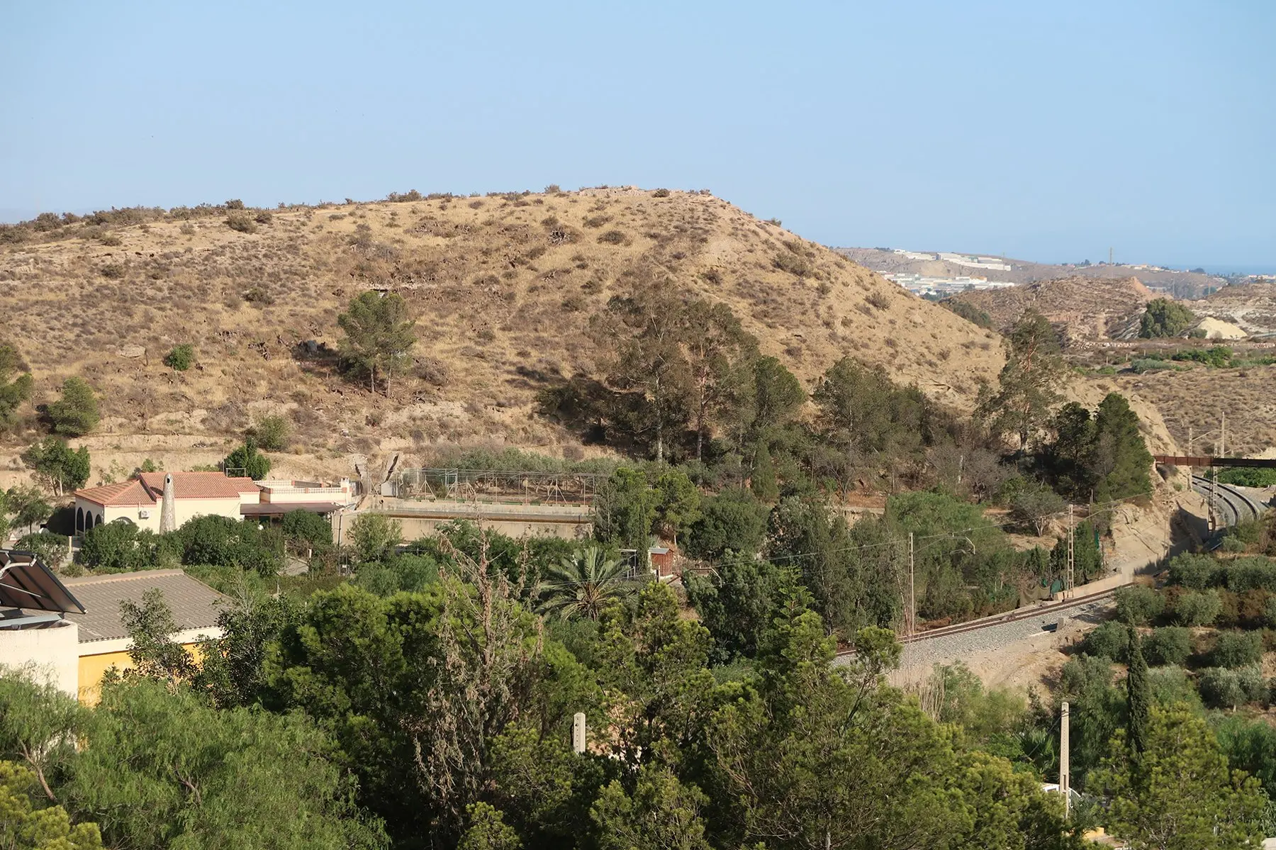 Vista del Cerro del Paredón desde los alrededores de El Chuche, a la derecha la vía férrea