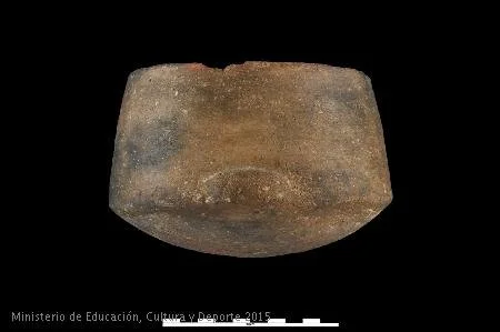 Cuenco de paredes rectas que se ensanchan ligeramente formando una carena con la base hemiesférica. La pasta, de colores negro y ocre, contiene desgrasantes medios y gruesos. Presenta un mamelón no perforado a la altura de la carena y bruñido en el interior y el exterior del recipiente. Fuente: MAN / Blog Entrecantaros